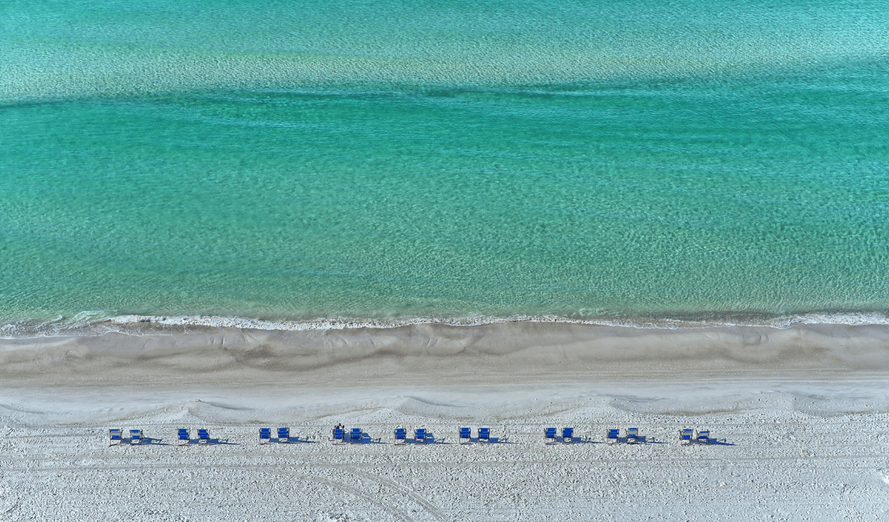 Aerial view of turquoise water and white sand beach destination popular for spring break travel by private jet charter